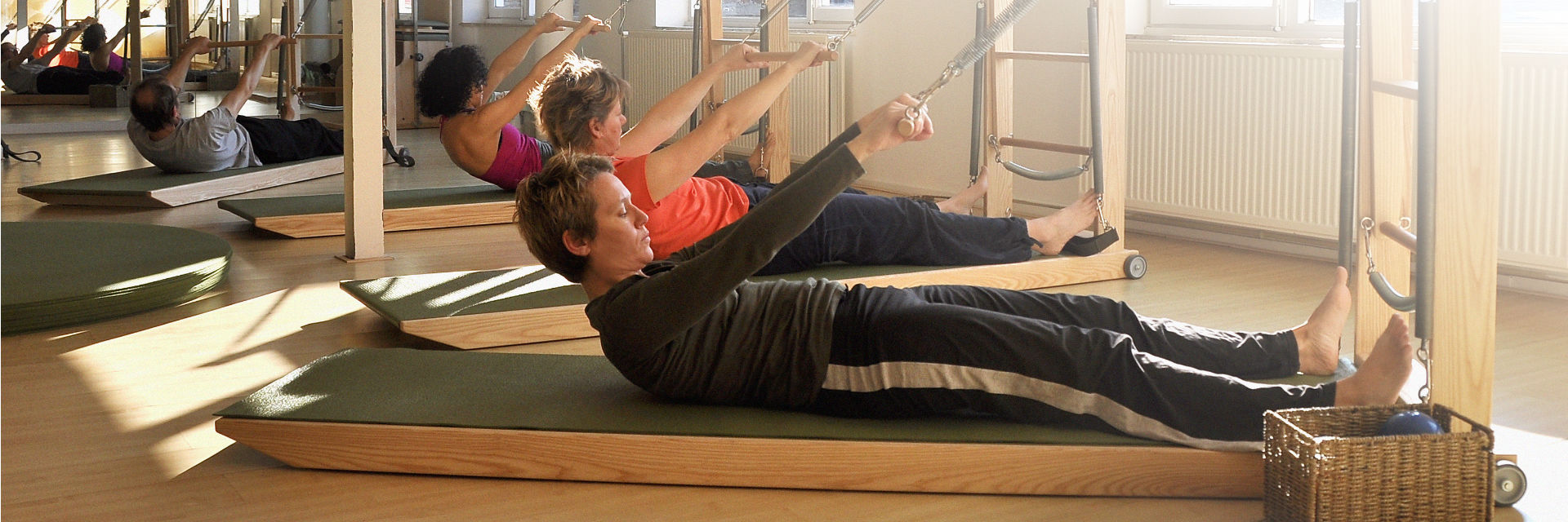 A group class on the unit: participants roll up with their arms reaching forward